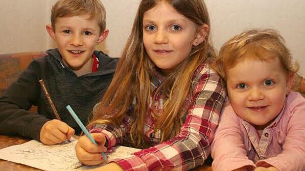 Die beiden Großen der Familie, Max und Marie, dürfen die Blätter zum Sonntagsevangelium ausmalen. Nesthäkchen Miriam ist noch zu klein dafür (von links). Foto: Evi Seeger