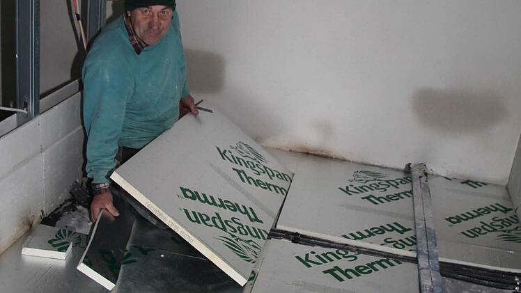 Bernd Sigmund verlegt Dämmplatten, die für höchste Energieeffizienz sorgen. Der Innenausbau ist in vollem Gange.
