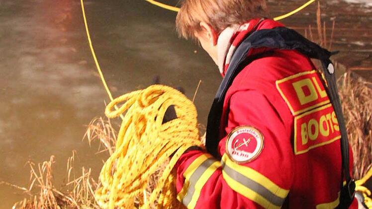 Ute Schubert sichert Stephan Trapper, der sich auf die Eisfläche wagt, mit einem Seil. Foto: Matthias Einwag