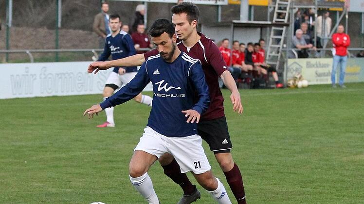 Frohnlachs Max Weinreich (blau) versucht den Ball vor Johannes Winkelmann von der SpVgg Erlangen abzuschirmen.