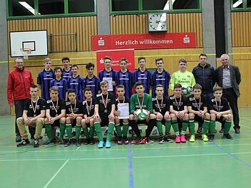 Die SG Haig (sitzend) mit Betreuer Henry Trebes (links) hat am Sonntagabend den Hallensparkassencup der B-Junioren gewonnen. Zweiter wurde die SG Theisenort (blau-schwarze Trikots). Mit im Bild Robert Porzelt von der Sparkasse (links stehend) sowie Kreisjugendleiter Michael Deuerling und der Theisenorter Betreuer Christian Löffler (von rechts). Foto: Hartmut Neubauer