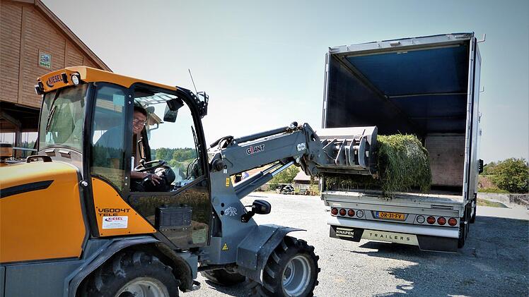 Michael Sack entlädt das gebundene Kleegras aus Donauwörth vom Lastzug. Foto: Werner Reißaus
