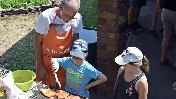 Beim Grillen (von links): Richard Skop vom Betreuten Wohnen Haus Windsburg und die Sch&uuml;lerinnen Noah Henkel und Jana K&uuml;chler.