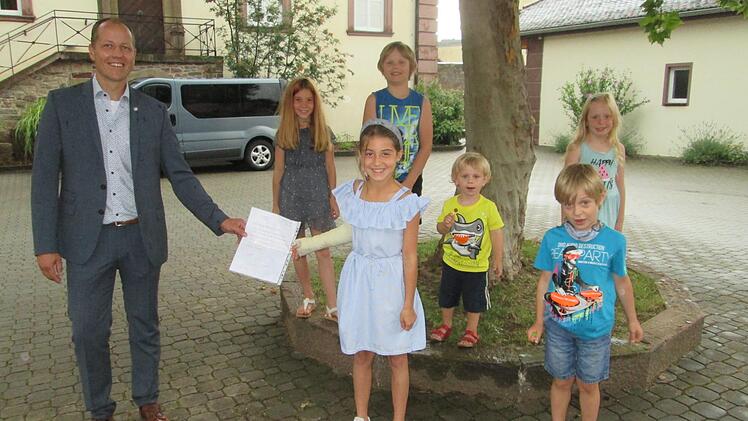 Da machen auch die Regentropfen nichts aus, wenn der Wunschtraum der jungen Machtilshausener im Erfüllung geht und Bürgermeister Johannes Krumm ihren Antrag im Gemeinderat unterstützt. Foto: Winfried Ehling