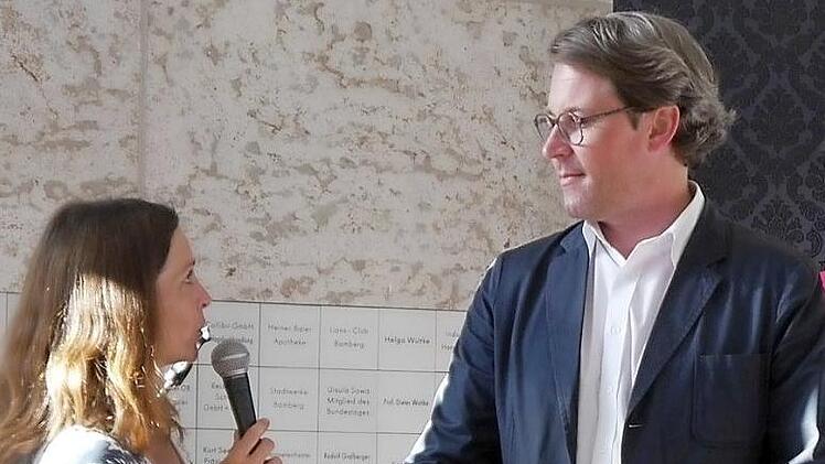 Die Moderatorin interviewt Generalsekret&auml;r Andres Scheuer.