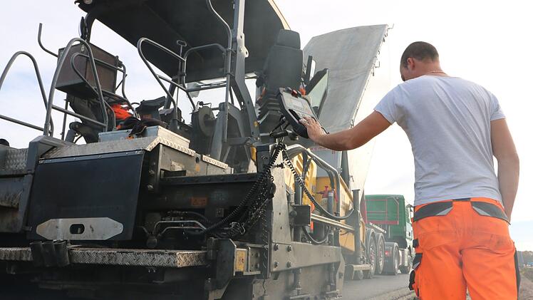 Die oberste Asphaltschicht wird aufgetragen. Foto: Ronald Heck