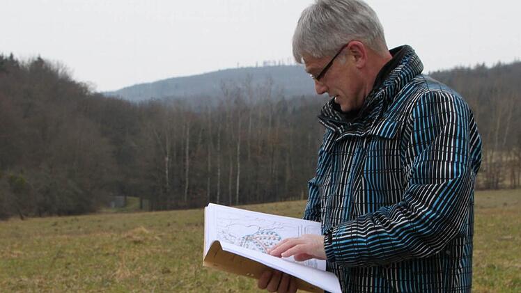 Noch kann Willi Scheller vom städtischen Büro Bauleistungen Bad Brückenau nur in Plänen blättern. Doch bald schon könnte hinter dem Baugebiet Oberes Straßfeld in Wernarz eine weitere Fläche für Häuslebauer erschlossen werden. Foto: Ulrike Müller
