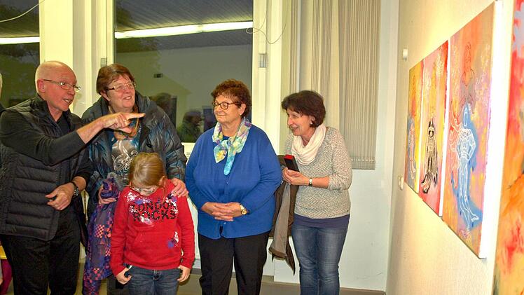 Viktor Cleve (li) erklärt interessierten Besuchern seine "Klöppelbilder".