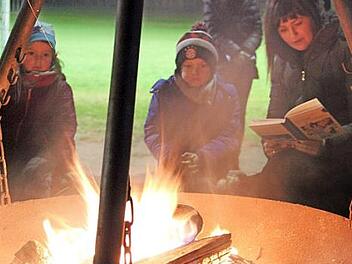 Die Kinder lauschten den Geschichten, die Romy Denk am Lagerfeuer vorlas. Foto: Katharina Müller-Sanke