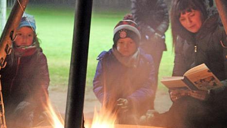 Die Kinder lauschten den Geschichten, die Romy Denk am Lagerfeuer vorlas. Foto: Katharina Müller-Sanke