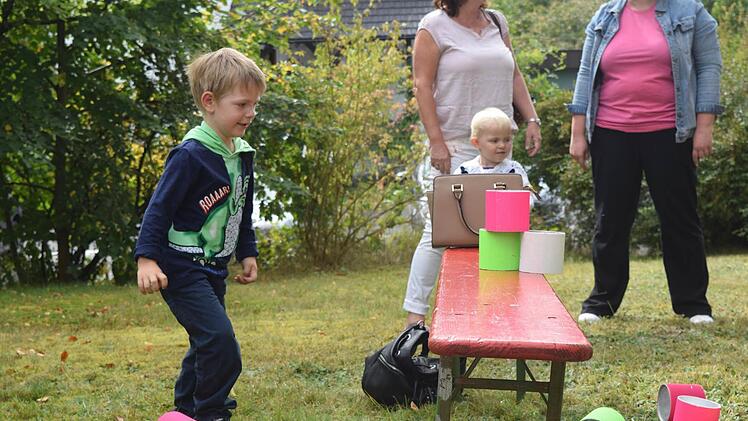 Auf diesen beiden Bildern wirft Lucien (vier Jahre alt) auf Dosen und seine Schwester Thara (zwei Jahre alt) schaut zu. Foto: Daniela Pondelicek