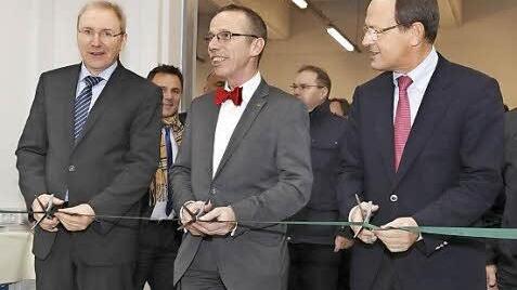Eröffnungszeremonie: Gemeinsam durchschnitten Prof. Dr. Peter Pleus, Bereichsvorstand Automotive (rechts), Dr. Arbogast Grunau (Mitte) und Dr. Alfred Pecher im Rahmen einer kleinen Feierstunde das grüne Band am Eingang zu den neuen Räumlichkeiten.