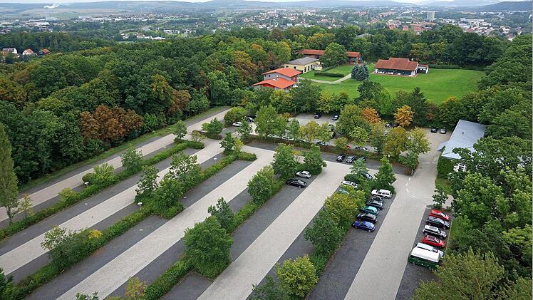 Der heutige Parkplatz der Hochschule, aufgenommen in den Semesterferien. Die neue Zufahrt würde durch den Wald rechts im Bild führen.