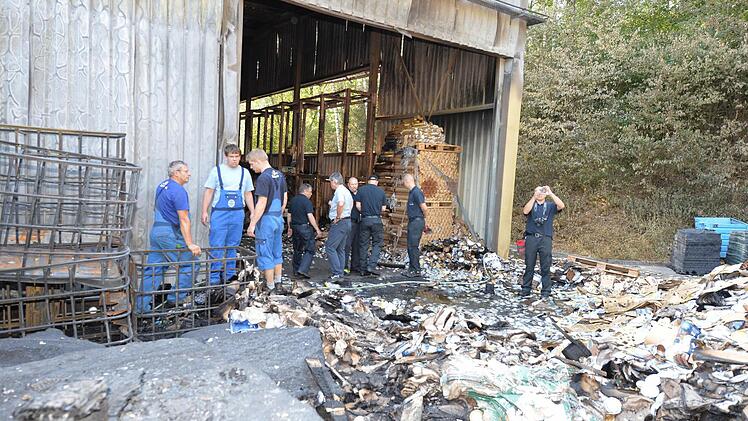 Brauerei-Mitarbeiter und Fachleute der Freiwilligen Feuerwehr Bamberg an der ausgebrannten Halle Foto: Ronald Rinklef