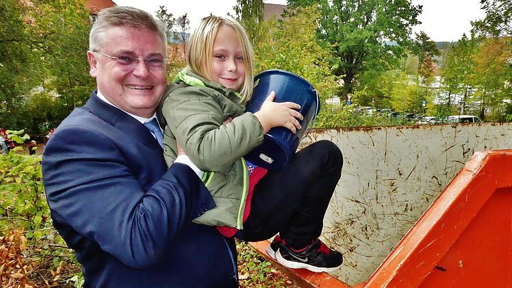 "Da komm ich mit meinem Apfeleimer ja nicht ran", stellt der kleine Marlon fest. Bankvorstand Thomas Siebenaller hilft deshalb ein wenig nach. Foto: Bernd Kleinert