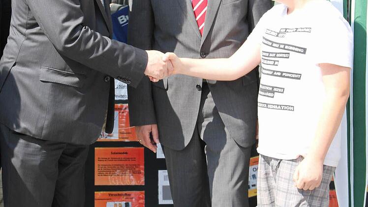 Der Bayerische Wirtschaftsminister Martin Zeil schüttelt Hendrik Schmitt, Schüler der Pater-Lunkenbein-Schule in Ebensfeld die Hand.