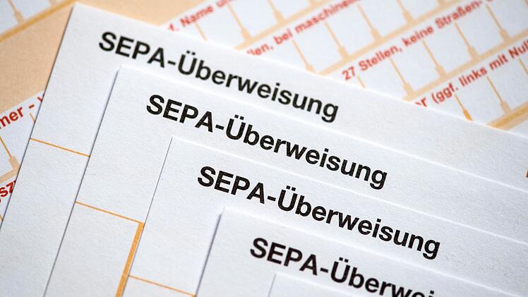 SEPA-&Uuml;berweisungsscheine liegen auf einem Tisch