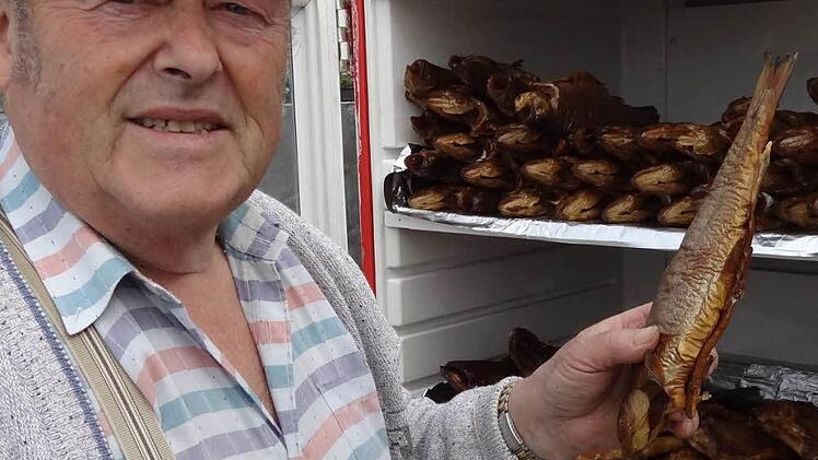 Peter Ackermann präsentiert seine frisch geräucherten Forellen.