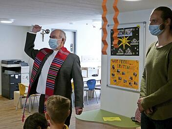 Pfarrer Armin Haas segnet, begleitet von KiTa-Leiter Franziskus Gerr und den Kindern, die neuen Räume der Kindertagesstätte St. Anna.