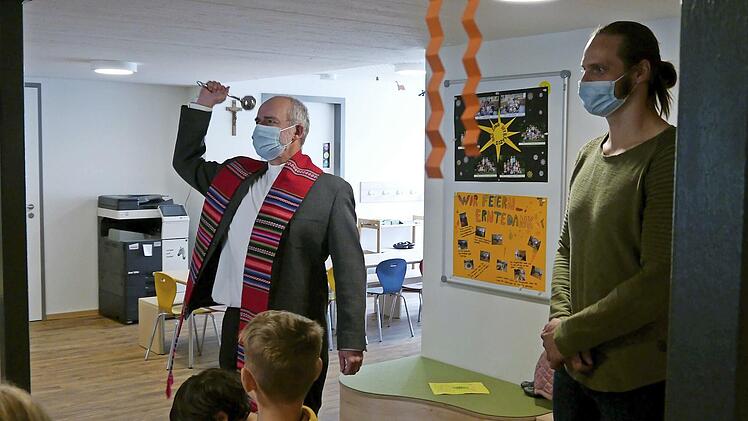 Pfarrer Armin Haas segnet, begleitet von KiTa-Leiter Franziskus Gerr und den Kindern, die neuen Räume der Kindertagesstätte St. Anna.