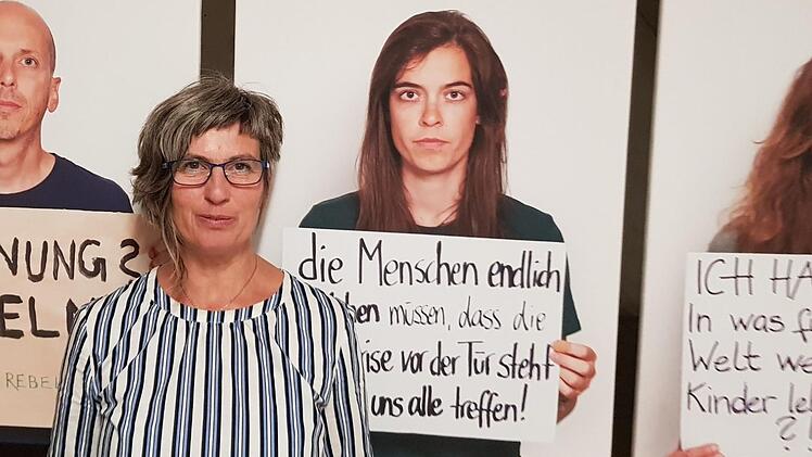 Veranstalterin Katharina Winkler vor den Porträts der Gruppe "Extinction Rebellion". Aktivisten der Gruppe werden bei der Ausstellungseröffnung am Samstag in Weißenohe sein, um den Besuchern das Thema "Gewaltfreier Widerstand" näherzubringen.  Fotos: Ekkehard Roepert
