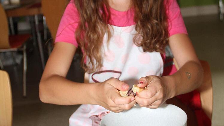 Flora zerbröselt einen ganz normalen Rührkuchen für Cake-Pops.  Foto: Gerda Völk