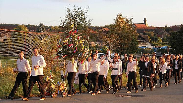 Fröhlich zog die Dorfjugend mit dem bunt geschmückten Kirmesbaum durch den Ort.