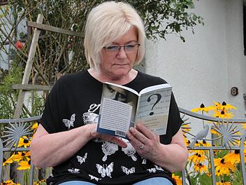 Die Woffendorferin Margitta Gückel hat nach sechs Jahrzehnten ihren Verwandtenkreis vergrößert. Angeregt blättert die 69-Jährige in der Biografie ihres ungewöhnlichen Lebens, in dem noch Fragen offen sind. Foto: Stephan Stöckel