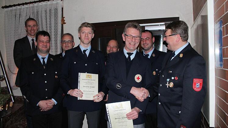 Die für zehn Jahre Engagement geehrten Mitglieder Gerold Weber (Dritter von rechts) und Christian Dreßel (Fünfter von rechts) mit dem neu gewählten Vorstand, Bürgermeister Bernd Höfer (links) und Kreisbrandinspektor Stefan Püls (Dritter von links) sind gut gelaunt bei der Übergabe der Ehrungsurkunden. Foto: Stephan Neumann