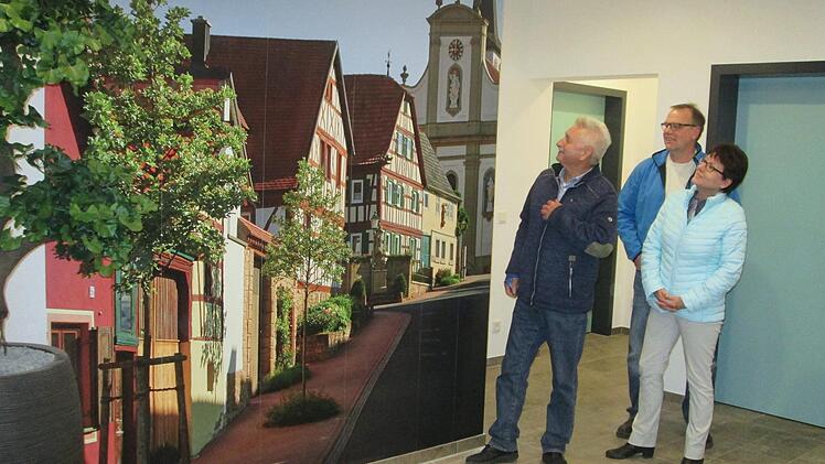 Ein Bild "wie gemalt". Bürgermeister Peter Hart, Rainer Heid und Gudrun Böhm (von links) bestaunen die Fototapete im Foyer des "Eulentreffs" in Fuchsstadt.