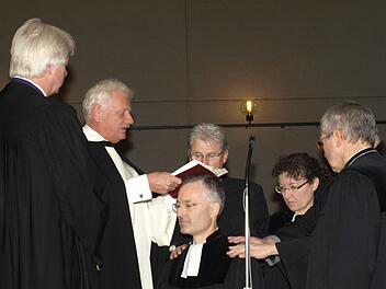 In der Kirche St. Burkard führten Bischof Karl-Hinrich Manzke und Dekan Peter Jentsch Pfarrer Jochen Fiedler als neuen Seelsorger für das Aus- und Fortbildungszentrum Oerlenbach ein. Auf unserem Foto legen ihm Mitbrüder die Hand auf und sprechen einen Segensgruß. Fotos: Stefan Geiger