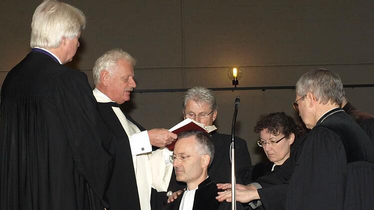 In der Kirche St. Burkard führten Bischof Karl-Hinrich Manzke und Dekan Peter Jentsch Pfarrer Jochen Fiedler als neuen Seelsorger für das Aus- und Fortbildungszentrum Oerlenbach ein. Auf unserem Foto legen ihm Mitbrüder die Hand auf und sprechen einen Segensgruß. Fotos: Stefan Geiger