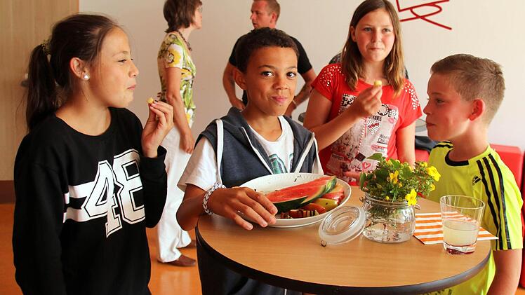 Kevin Meister, Ines Oppel, Tevis Zeigler und Ana Moore (von rechts) lassen sich Melonenstücke und Apfelschnitze schmecken, während Coach Hiltrud Drachenberg und Caterer Ronny Schmidt im Hintergrund das Erreichte besprechen.Foto: Bettina Knauth