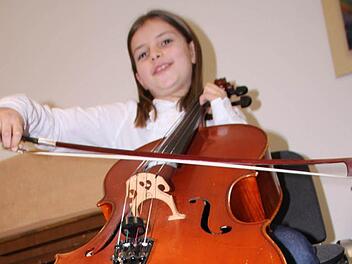 Jette Jäger aus Bad Brückenau möchte unbedingt Cello lernen und probiert das Instrument schon mal aus. Foto: Ulrike Müller