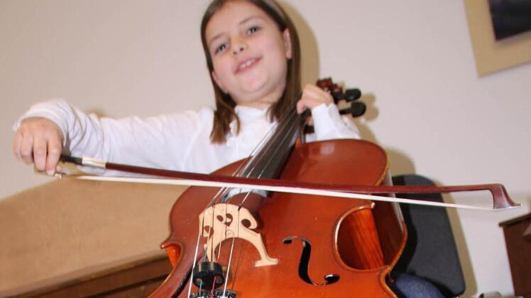 Jette Jäger aus Bad Brückenau möchte unbedingt Cello lernen und probiert das Instrument schon mal aus. Foto: Ulrike Müller