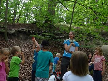 Kinder versammeln sich mit Heike Gögelein vom Haus der Schwarzen Berge an der "Zwergenbuche". Foto: Kindergarten St. Georg