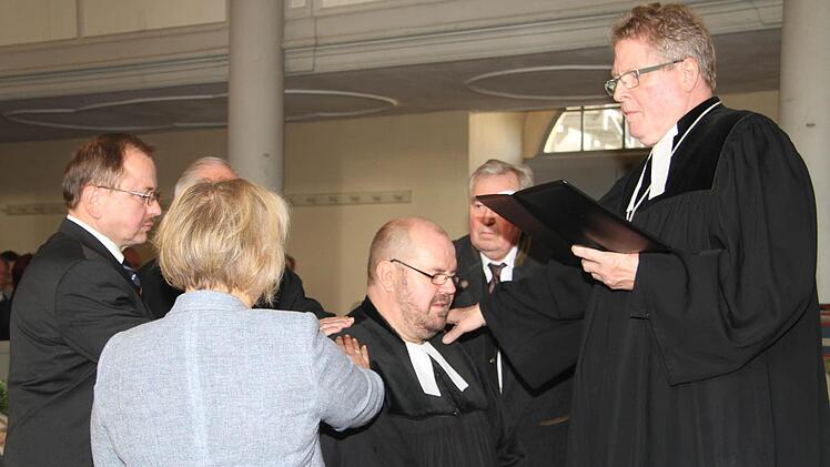 Assistenten legten die Hand auf - Dekan Jürgen Zinck ernannte Pfarrer Christian Schmidt offiziell zum Pfarrer. Foto: Sonja Adam