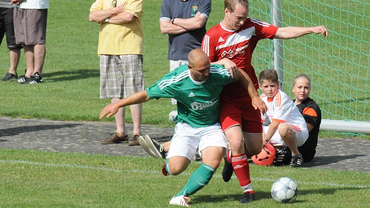 Den Gegner bereits beim Ballbesitz st&ouml;ren, ist die Maxime des Riedenbergers Daniel Dorn (links) im Duell mit Matthias Tratt vom VfR Stadt Bischofsheim. Foto: ssp