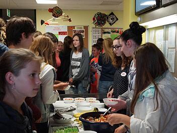 Schüler drängeln sich um die Tische mit Obstsalat und vegetarischem Chili aus fair gehandelten Zutaten. Foto: Arkadius Guzy