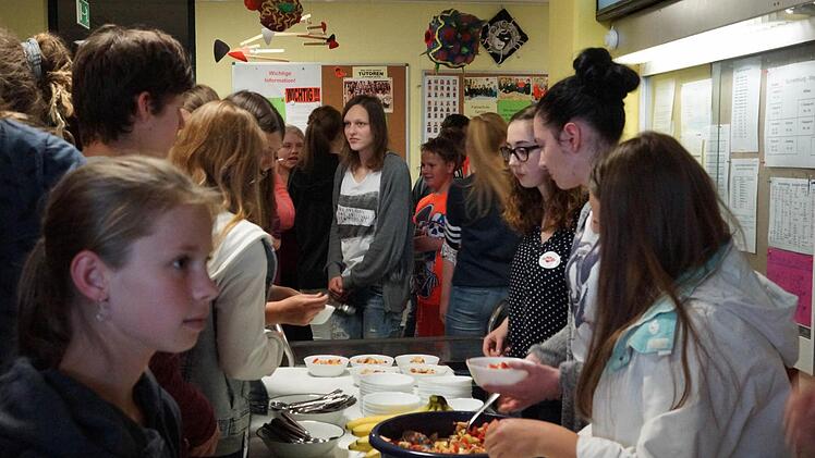 Schüler drängeln sich um die Tische mit Obstsalat und vegetarischem Chili aus fair gehandelten Zutaten. Foto: Arkadius Guzy