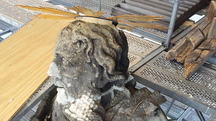 Die Figur des Apostels Paulus an der Westfassade (hier zwischen den Gerüstflächen) ist ein Fall für die Restauratoren: Die weißen Flecken sind Steinergänzungen, die sich im Laufe der Zeit durch Abwitterung und UV-Licht farblich verändert haben. Foto: Staatliches Bauamt Bamberg.