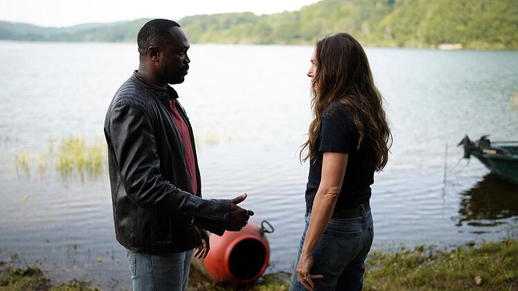 Der ortsans&auml;ssige Polizist Didier Bousquet (Otis Ngoi) erkl&auml;rt seiner neuen Kollegin No&eacute;mie Chastain (Laura Smet), was es mit dem Stausee auf sich hat.
