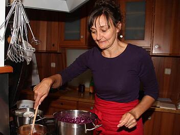 Regina Burkhardt gießt die kochend heiße Zucker-Essig-Mischung über das gesalzene Blaukraut. So bleibt die schöne violette Farbe erhalten. Fotos: Sonja Adam