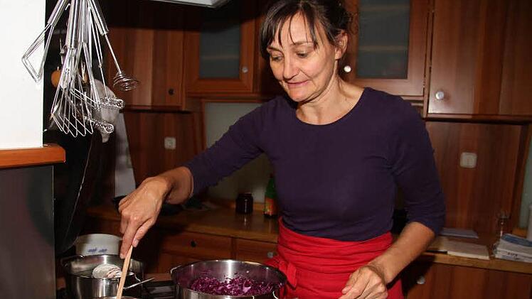 Regina Burkhardt gießt die kochend heiße Zucker-Essig-Mischung über das gesalzene Blaukraut. So bleibt die schöne violette Farbe erhalten. Fotos: Sonja Adam