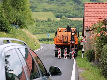 Mitarbeiter der Straßenmeisterei haben im Juli die Staatsstraße zwischen Sulzthal und Euerdorf notdürftig ausgebessert. Wann der eigentliche Ausbau kommt, ist aktuell noch offen. Der Eigentümer der ehemaligen Mühle (rechts) hat seit zwei Jahren nichts mehr gehört. Foto: Ralf Ruppert