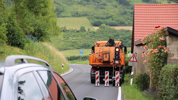 Mitarbeiter der Straßenmeisterei haben im Juli die Staatsstraße zwischen Sulzthal und Euerdorf notdürftig ausgebessert. Wann der eigentliche Ausbau kommt, ist aktuell noch offen. Der Eigentümer der ehemaligen Mühle (rechts) hat seit zwei Jahren nichts mehr gehört. Foto: Ralf Ruppert