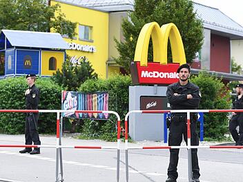 Polizeibeamte stehen am 23.07.2016 vor dem McDonald's Schnellrestaurant am Olympia-Einkaufszentrum OEZ in München, einen Tag nach einer Schießerei mit Toten und Verletzten. Foto: Sven Hoppe/dpa