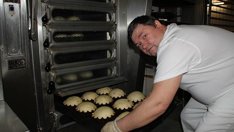 Alexander Hahn schiebt die Hefebrote mit Rosinen in den Ofen.