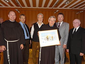 Die Kreuzbergmusikanten haben Pater Martin zum Abschied ein Bild vom Kreuzberg mit zwei Langläufern im Vordergrund überreicht. Das Foto entstand anlässlich der Verabschiedung und zeigt von links: Pater Stanislaus Wentowski, Franz Reder, Dr. Martin Wünsch, Pater Martin, Bürgermeister Udo Baumann und Prälat Bernold Rauch. Foto: Marion Eckert