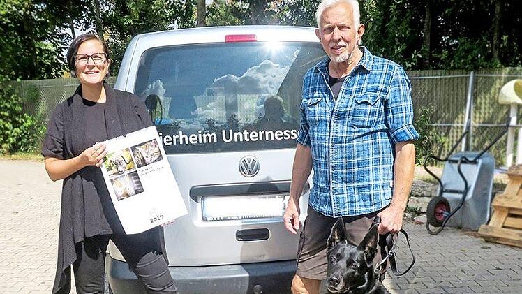 Die Fotografin Anja Veh mit dem Kalender und Wolfgang Bläsing, dem Vorsitzenden des Tierschutzvereins, mit Tash, einer neunjährigen holländischen Schäferhündin, die erst vor kurzem im Tierheim abgegeben wurde. Foto: Johanna Blum